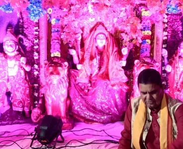 Singer performing bhajans beside a decorated Mata darbar